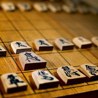 古く使い込まれた将棋盤と駒の写真
