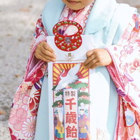 千歳飴の袋を持つ着物姿の子どもの写真