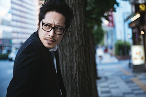 尾行に気づき後ろを振り返る不倫中の男性スーツ姿