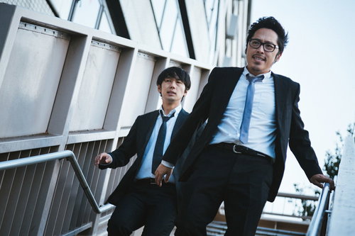 特ダネを追うジャーナリスト刑事達が階段を駆け上がる