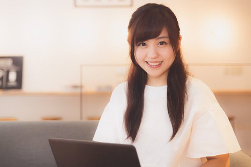 伊万里市のコワーキングスペースでノートパソコンを操作する笑顔の女性