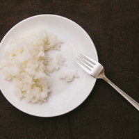 白いお皿に盛られたライス食べきれず残されたご飯の写真