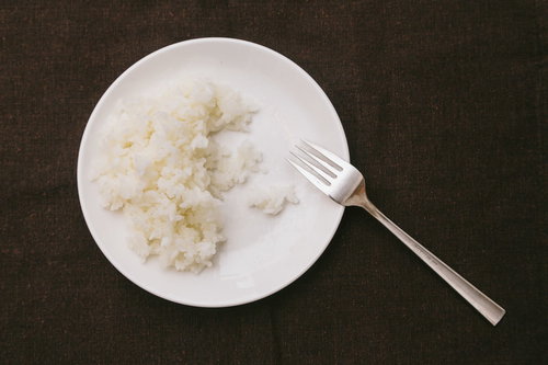 白いお皿に盛られたライス食べきれず残されたご飯