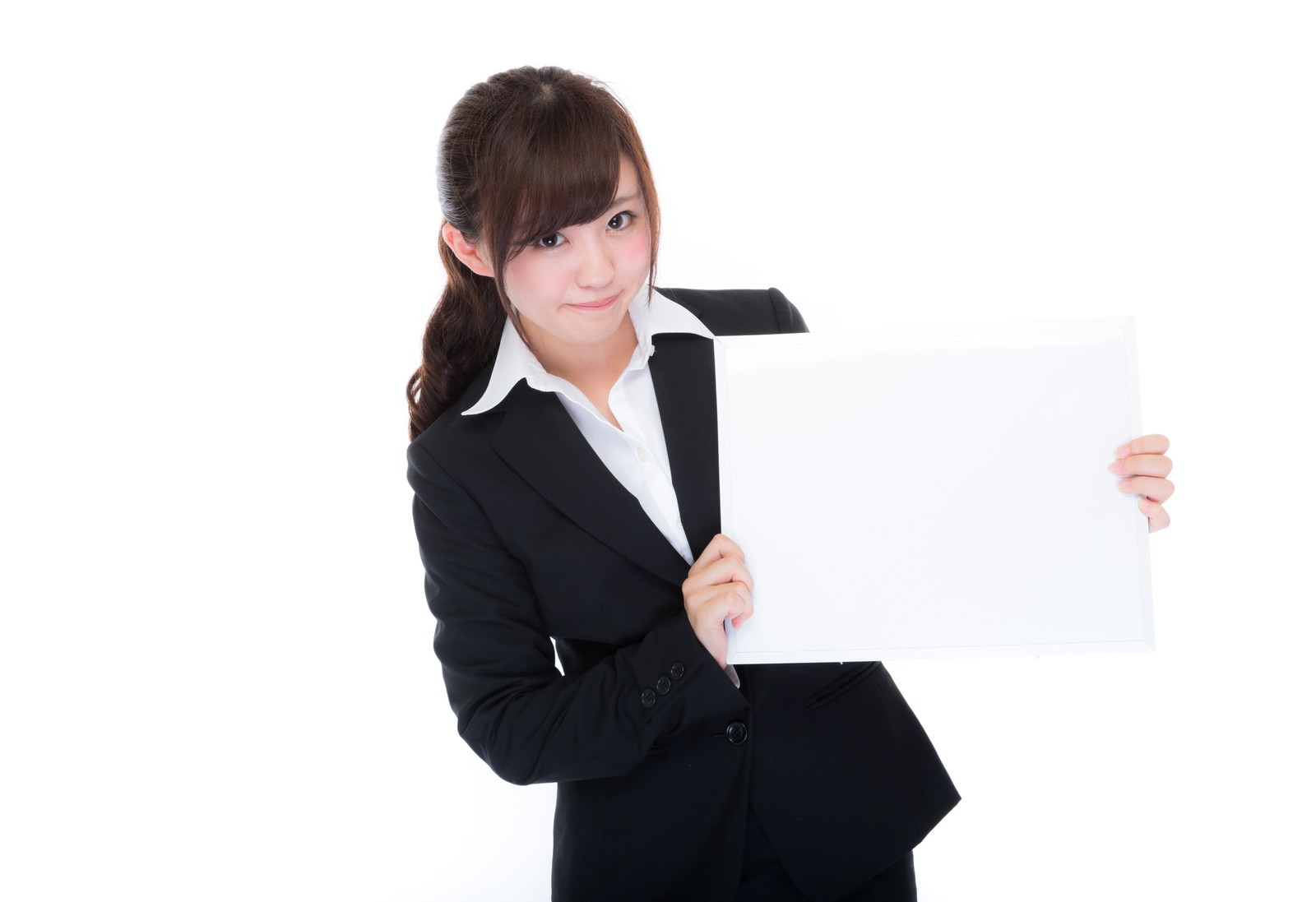 黒スーツを着た女性社員がフリップを持って説明している［モデル：河村友歌］