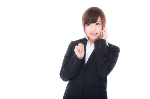 お昼のランチブッフェを予約する若い女性社員がスマートフォンで通話