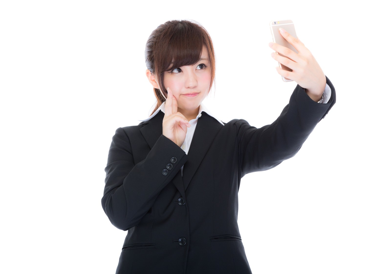 黒いスーツの女性がスマホで自撮りをしている［モデル：河村友歌］