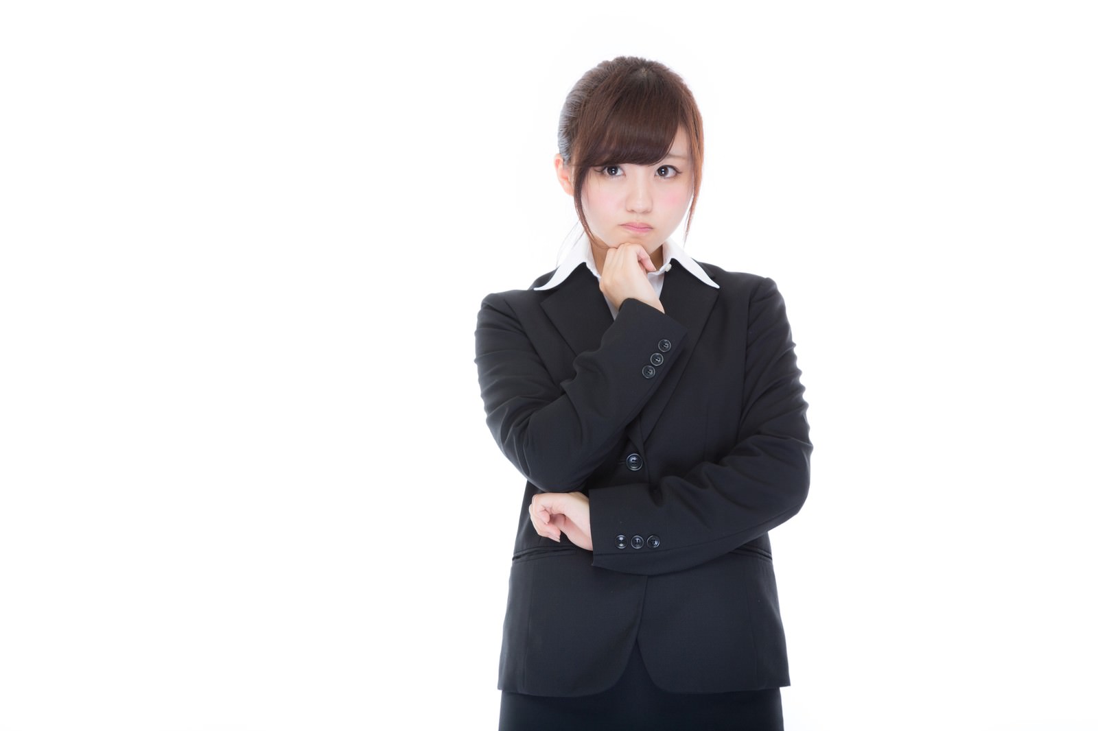スーツを着た女性が考え事をしながら頭を傾ける［モデル：河村友歌］