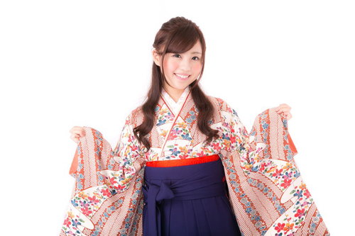 花柄の着物と紺色の袴で笑顔の女性、両腕を広げて