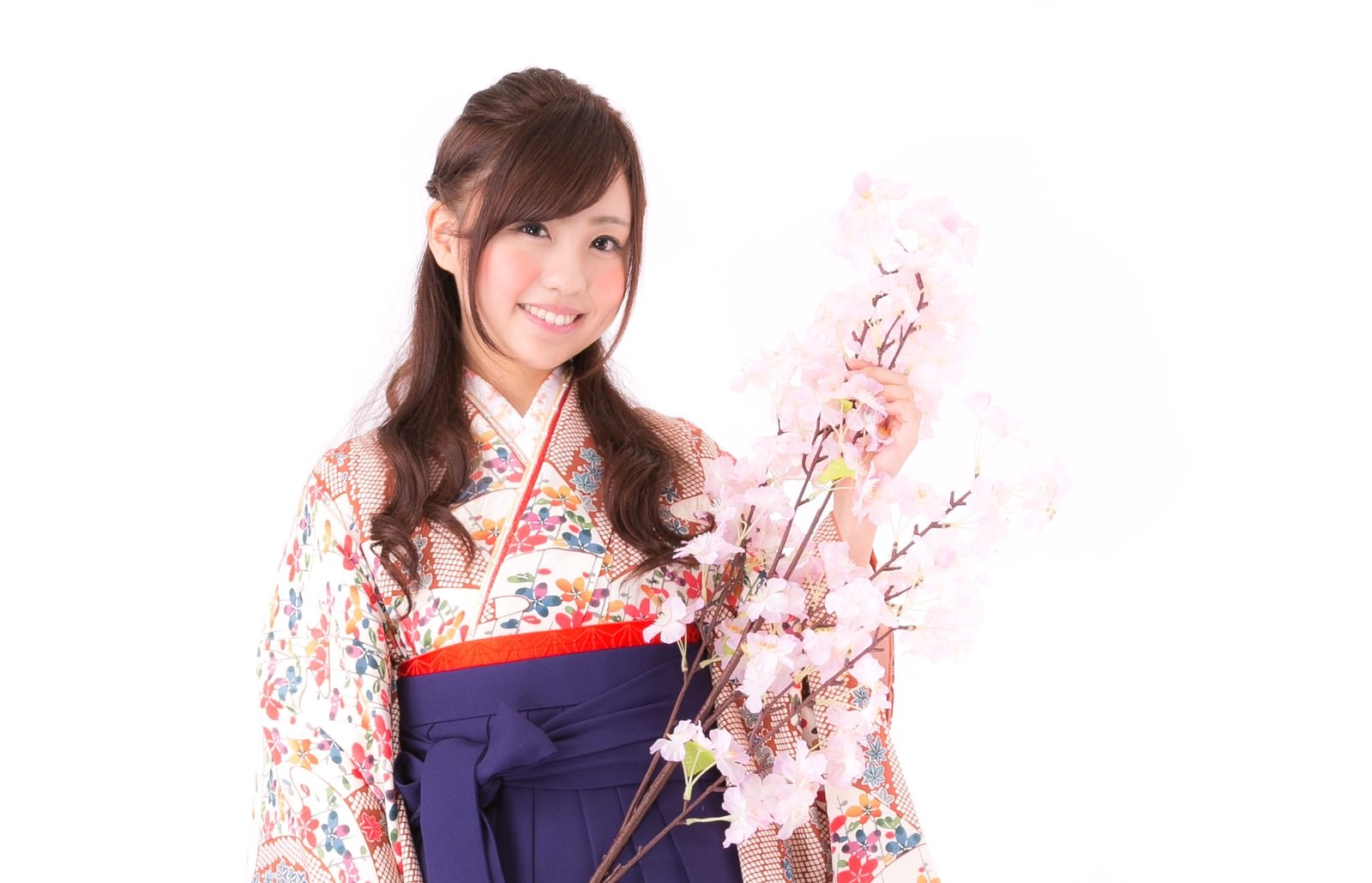 ピンク色の桜の花を持ち微笑む、花柄着物姿の女性［モデル：河村友歌］