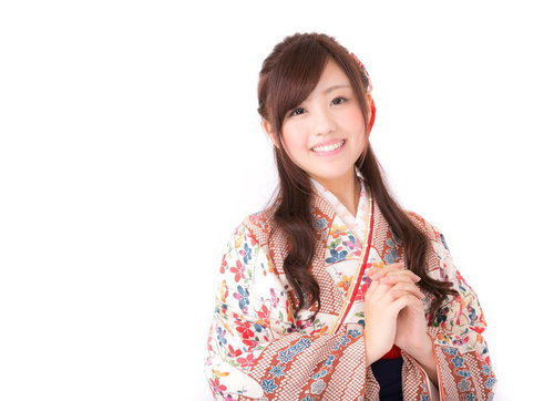 素敵な一年になりますように、赤い帯紐の着物姿で笑う女性