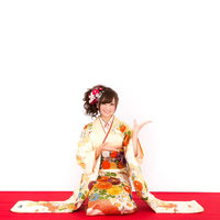 新年のお知らせを持つ振袖姿の女性のポーズの写真