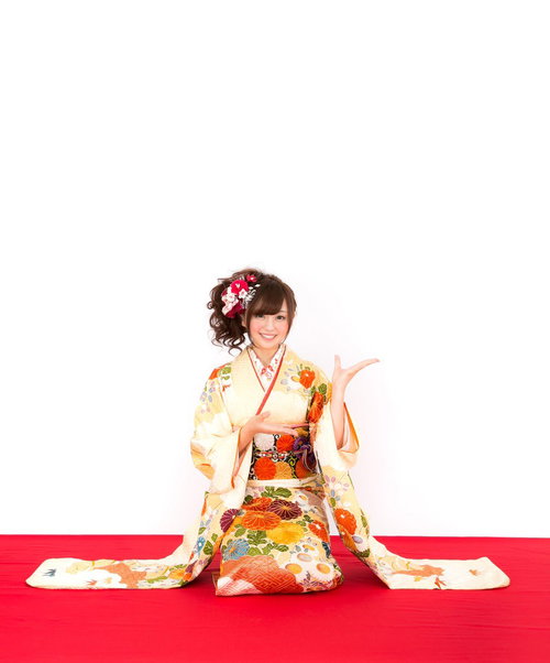 新年のお知らせを持つ振袖姿の女性のポーズ