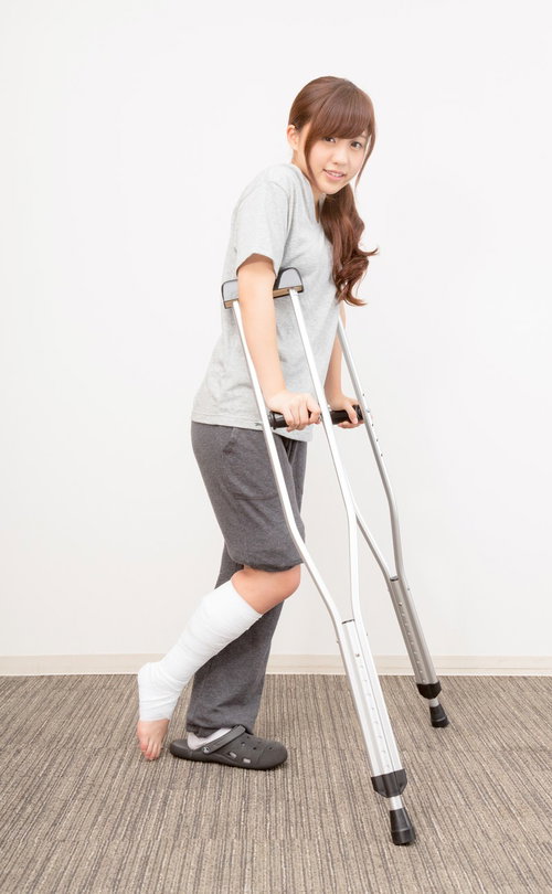 松葉杖で通院する女性の交通事故後のリハビリ