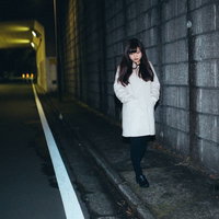 夜道をてくてく、薄暗いトンネル脇を歩く女性の写真
