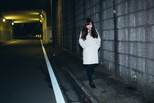 夜道をてくてく、薄暗いトンネル脇を歩く女性