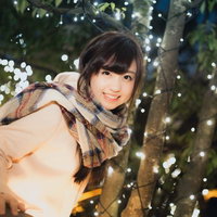ライトアップされた夜の樹の下ではしゃぐ彼女の写真