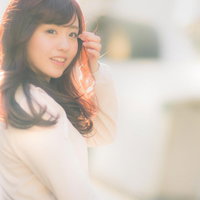 ちょっと風強いねと振り返る女性、夕方の屋外でポートレート撮影の写真