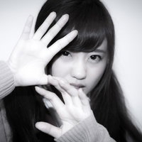 スクープを激写される女子高生が顔を手で覆う防御の仕草の写真