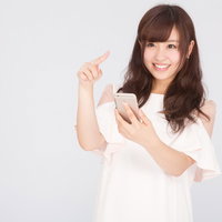 スマホでモンスターを捕まえるゲームに夢中なキラキラ女子の写真