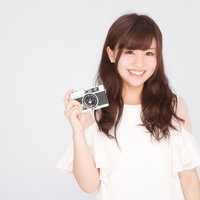 カメラを持ったカメラ女子の笑顔 - レトロカメラ撮影ポートレートの写真
