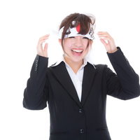 応援しすぎて必勝ハチマキが緩む女性社員の笑顔の写真
