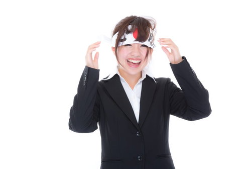 応援しすぎて必勝ハチマキが緩む女性社員の笑顔