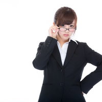 スケジュール管理ができない上司に指摘する眼鏡をかけた美人秘書の写真