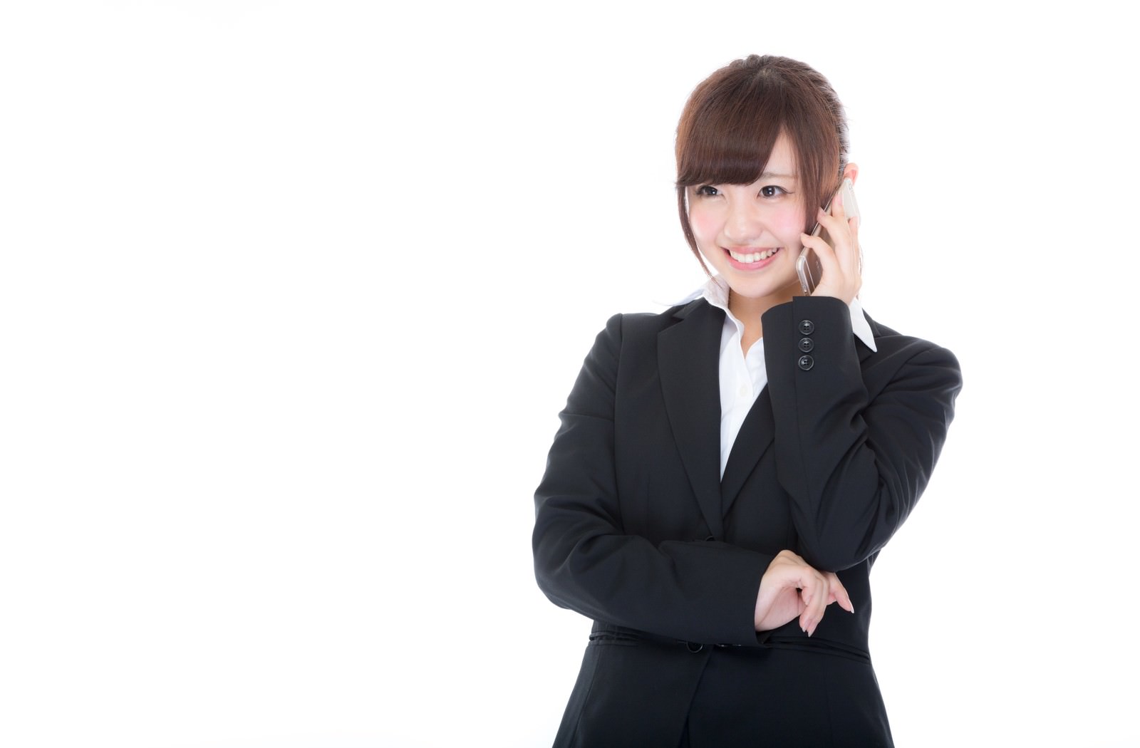 黒いスーツの女性がスマートフォンで電話対応をしている写真［モデル：河村友歌］