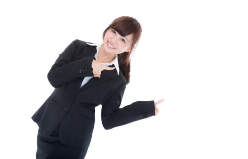 黒いスーツで両手で指をさす案内係の女性