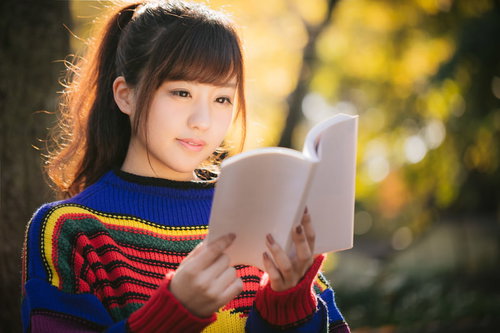 紅葉の秋とマルチカラーな読書着で本を読む女子