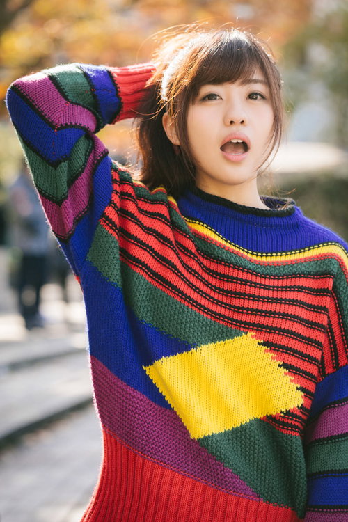 秋の陽気に映える80s風カラフルニットを纏う女性