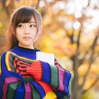 本を抱きしめるマルチカラーニットの読書女性の写真