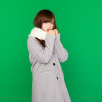 グリーンバックで撮影したマフラーを巻いたコート女子の写真