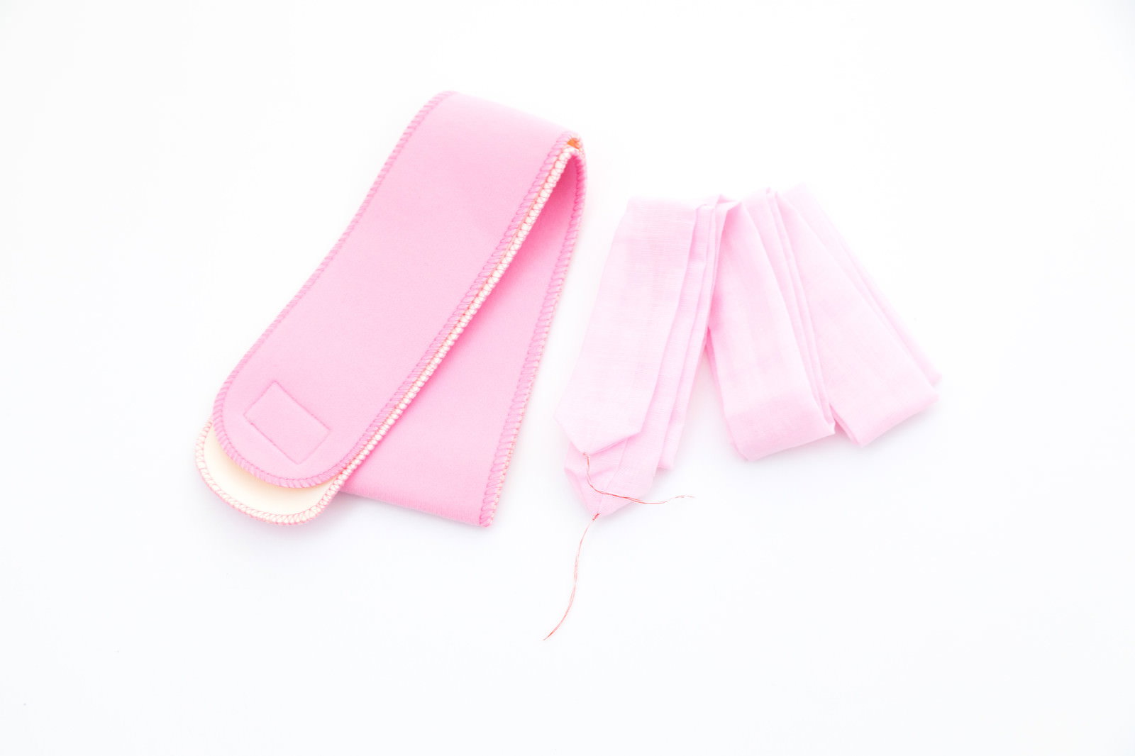 ピンク色の伊達締めと腰紐が白背景に並ぶ