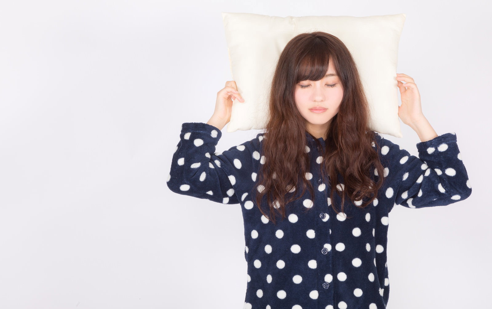 紺色の水玉パジャマを着た女性が両手を上げてポーズをとっている［モデル：河村友歌］