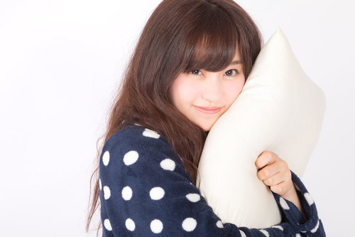 ワイ、抱きまくらになりたいと白い抱き枕を抱きしめる女性