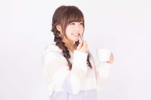 スマホを見て笑う三つ編みの女性