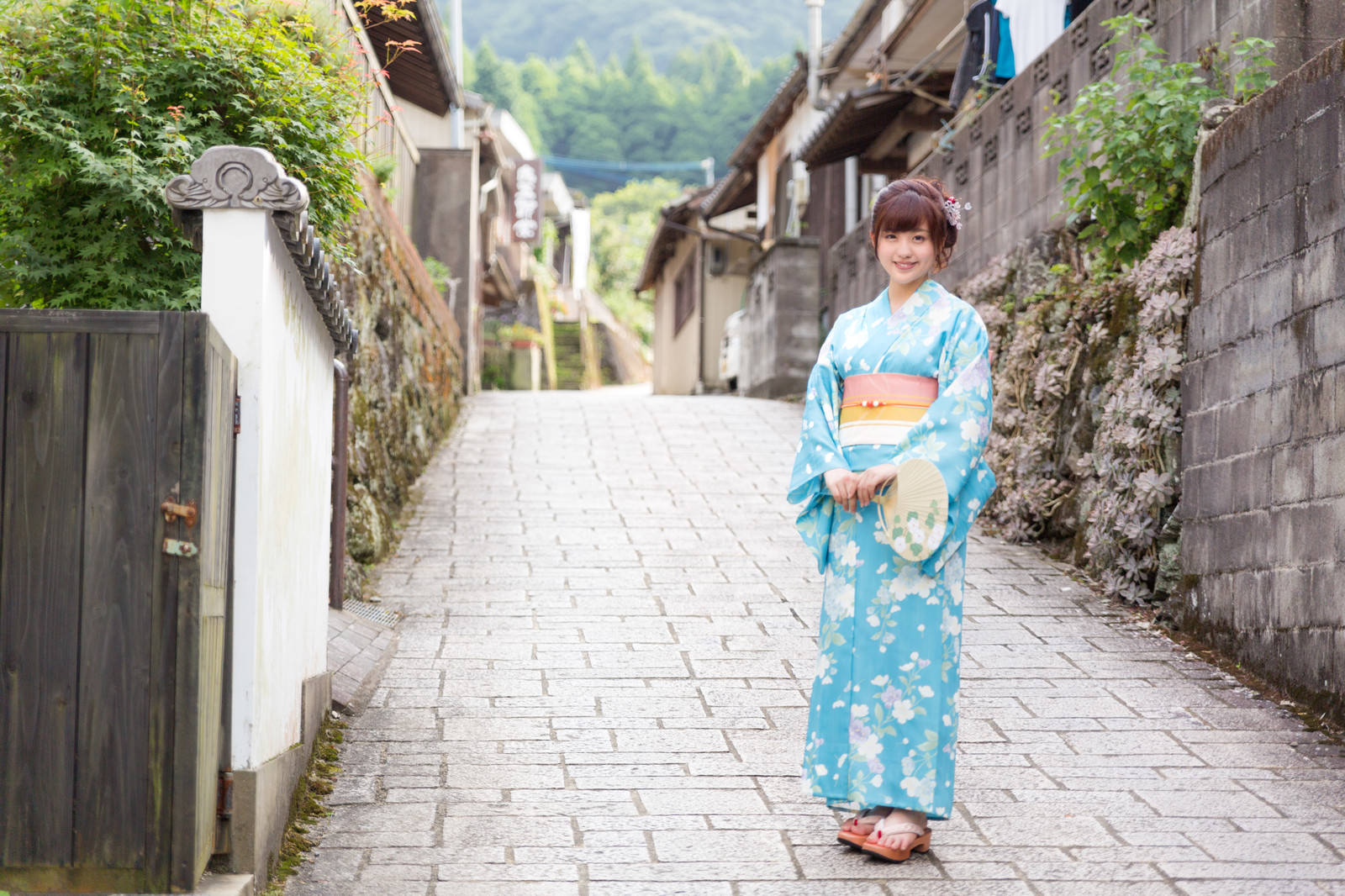 Woman in light blue yukata on stone path at Okawachiyama