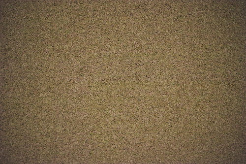 細かい粒子が均一に散りばめられたコルクボードのテクスチャー