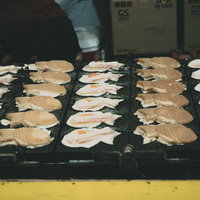 神農祭の屋台で焼かれるたい焼き、鉄板の上で熱々に仕上がる和菓子の写真