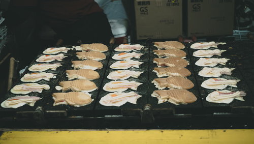 神農祭の屋台で焼かれるたい焼き、鉄板の上で熱々に仕上がる和菓子