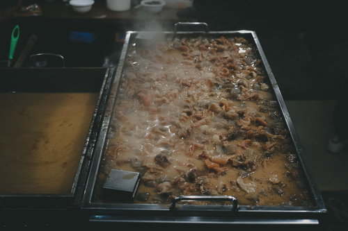 湯気が立ち上る屋台のモツ煮鍋