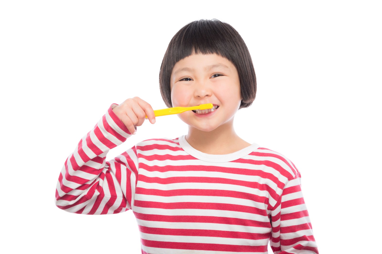 黄色い歯ブラシで歯を磨くピンク色の縞模様の長袖を着た小学生の女の子［モデル：ゆうき］
