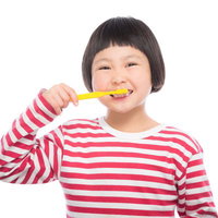黄色い歯ブラシで毎日歯磨き！前髪パッツンの小学生の写真