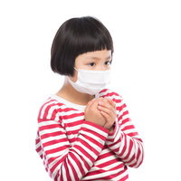 赤と白のボーダー服でマスク着用する小学生の写真