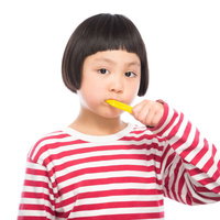 黄色い歯ブラシで歯磨きの練習をする女の子の写真