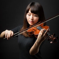 ヴァイオリンを演奏中の女性・黒い衣装で集中する演奏家の写真