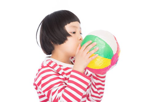 紙風船をプゥーするおかっぱの女の子