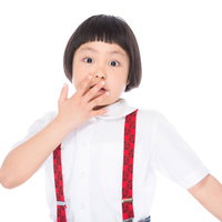 赤い吊りバンド姿でぶったまげたおかっぱ少女の写真