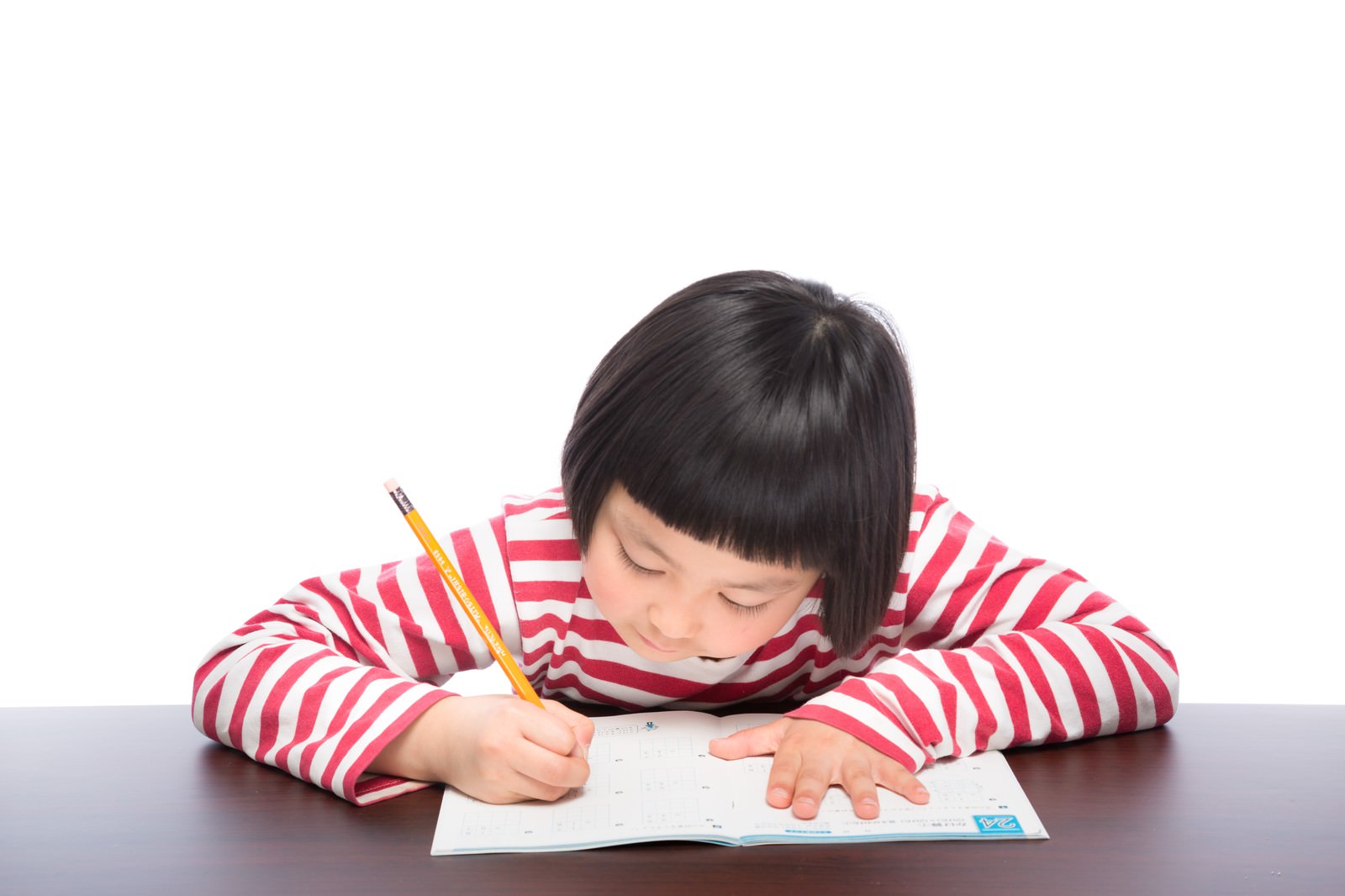宿題をしながら鉛筆で勉強する前髪パッツンの女の子［モデル：ゆうき］